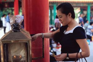 lighting incense in a temple